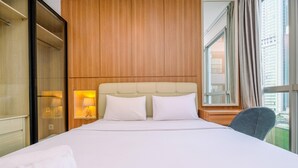 A hotel room with a large bed, wooden panel walls, a window with curtains, and a view of buildings. - Best Homey And Nice 1Br At Ciputra World 2 Apartment (Jakarta)