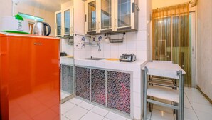 A compact kitchen with white cabinets, a sink, a toaster, and a refrigerator. - Comfort And Cozy Living 2Br At Cibubur Village Apartment (Depok)