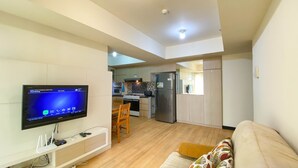 Una sala de estar moderna con un televisor de pantalla plana, un sofá y una zona de comedor.