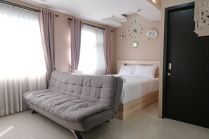 Ein modernes Schlafzimmer mit einer Schlafcouch, einem Bett und dekorativen Wanduhren.