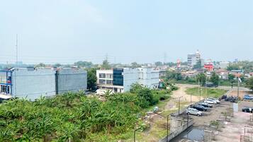 A parking area with several cars, a concrete pathway, and a building with a sign that reads "TENANG JAYA".