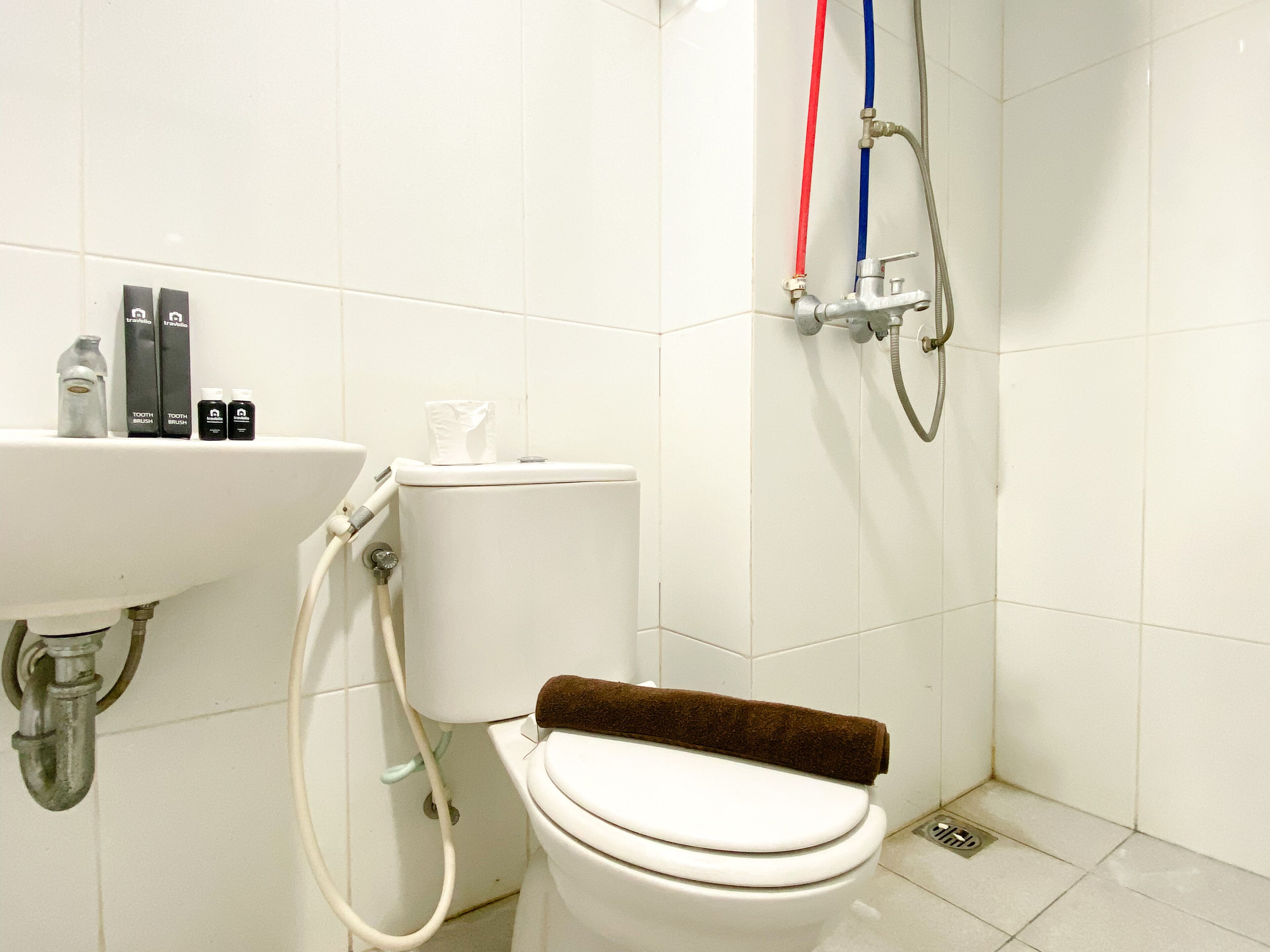 A bathroom with a toilet, sink, and shower.