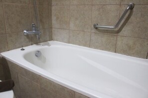 A standard bathtub with a handheld showerhead and a grab bar. - Warm 1Br Apartment (No Kitchen) At Marbella Suites Dago Pakar Bandung (Bandung)