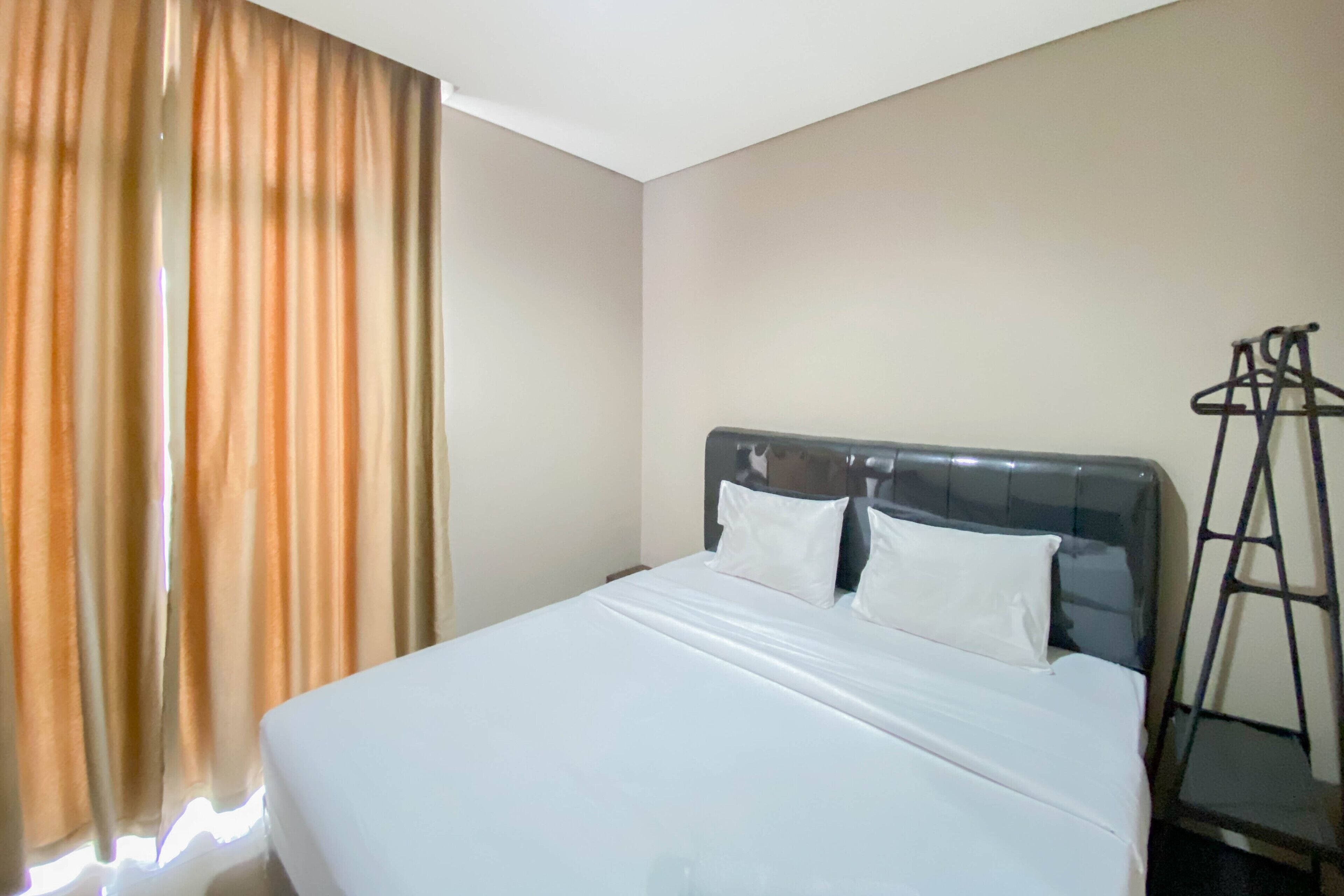 Une chambre d’hôtel avec un lit, des rideaux et une échelle.