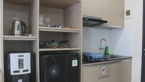 Eine kleine Küche mit Kaffeemaschine, Kühlschrank, Herd und Spüle.