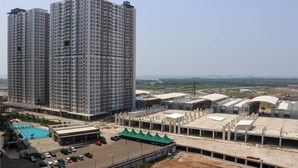Um edifício alto com vários andares, uma piscina e área de estacionamento.