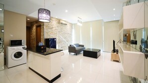 A modern kitchen with a built-in washing machine, a microwave, and a coffee machine.