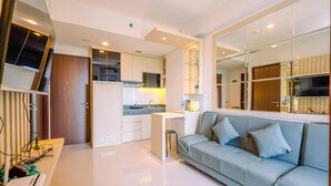 Una cocina moderna con armarios blancos, estufa integrada y una pequeña isla con un taburete.