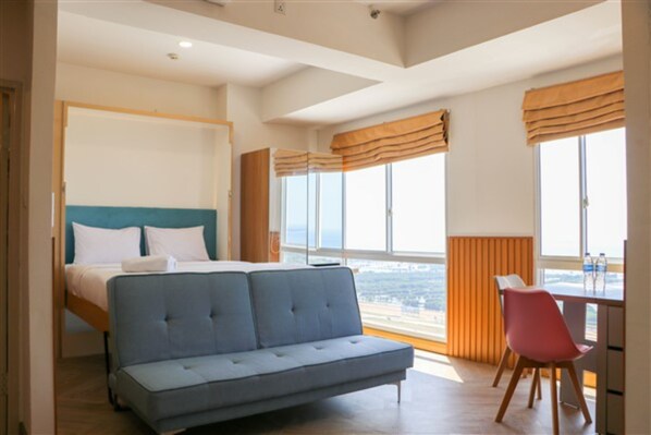 Relax in a stylish room with a large bed, sofa, and city view.