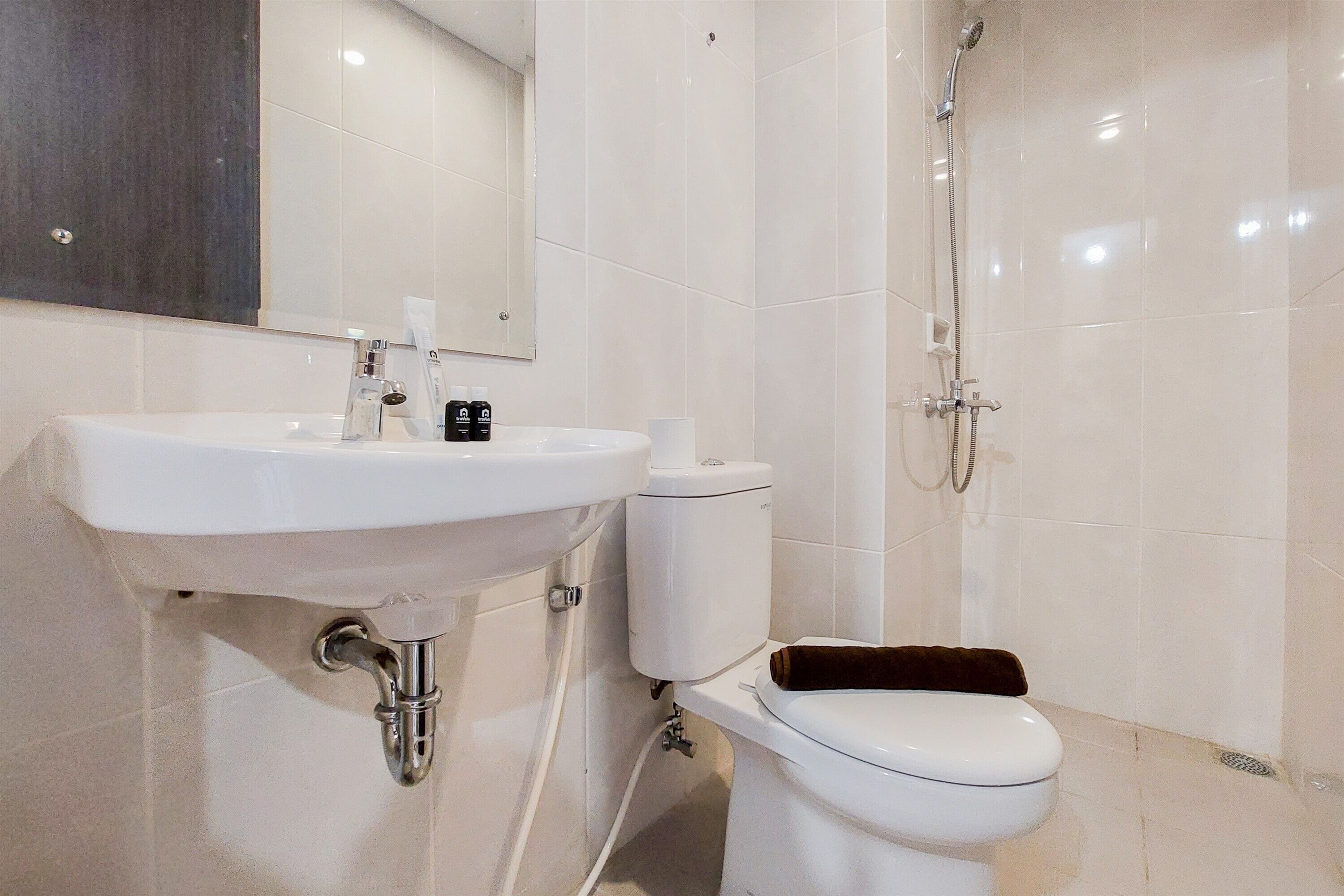 A bathroom with a white sink, toilet, and shower.