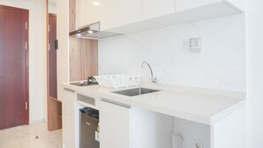 A modern kitchen with white cabinetry, a stainless steel sink, and a built-in dishwasher.