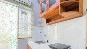 Une cuisine avec des carreaux blancs, un évier, un plan de travail et des armoires en bois.