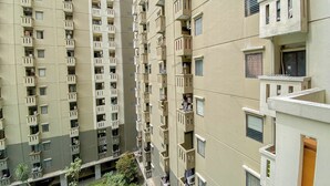 Un immeuble résidentiel de grande hauteur doté de nombreux balcons, d’une cour intérieure et d’une variété de styles de fenêtres.