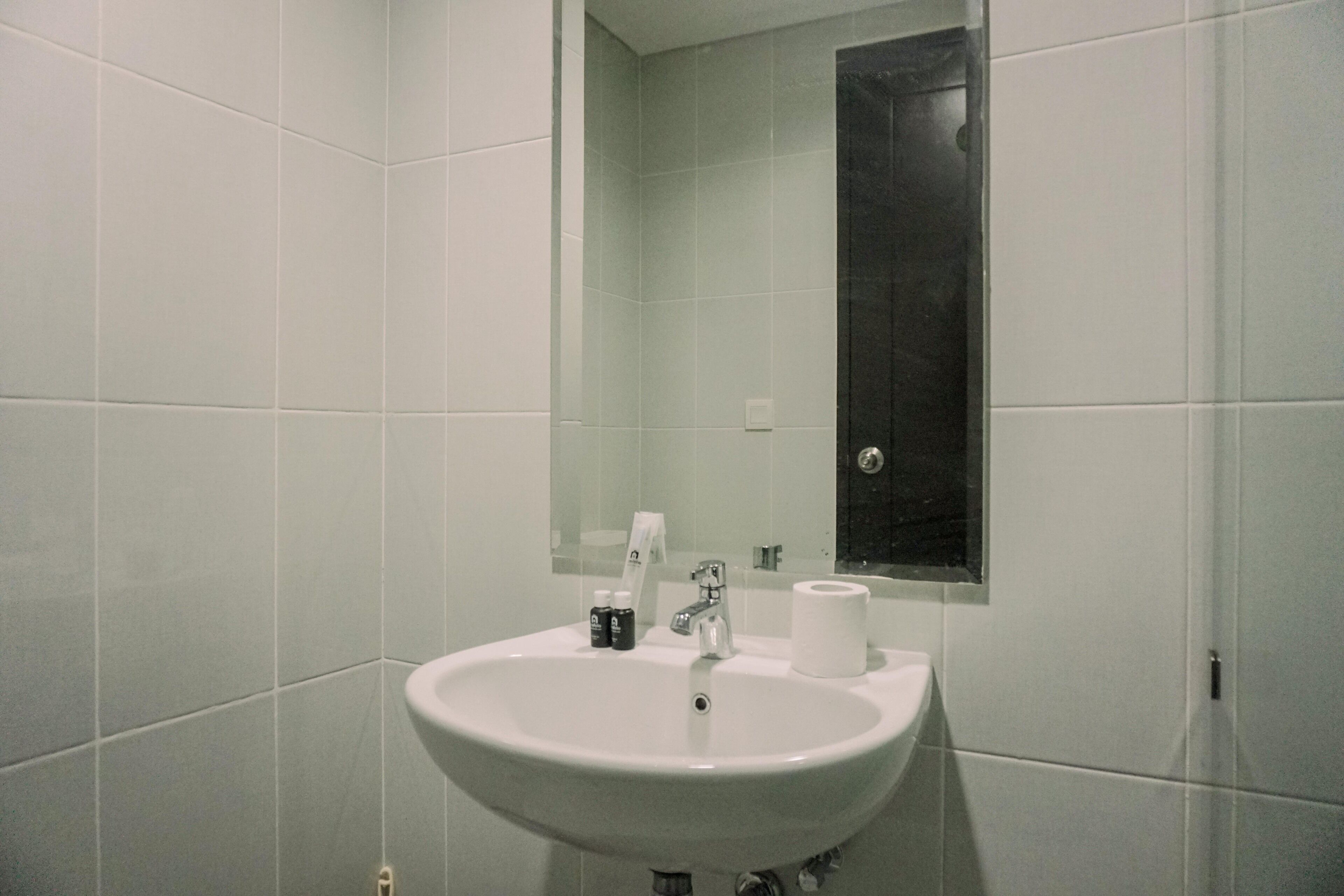 Un baño con un lavamanos blanco, un espejo y un inodoro.