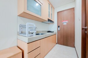 A compact kitchen with wooden cabinets, a built-in microwave, and a sink.