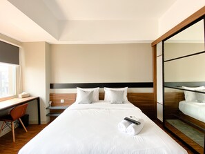 Ein Hotelzimmer mit Bett, Schreibtisch und großem Spiegel.