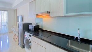 Uma cozinha moderna com máquina de lavar, micro-ondas e pia.
