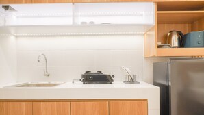 A kitchen with a stainless steel sink, a toaster, and a refrigerator. - Homey Living Studio Room At Tokyo Riverside Pik 2 Apartment (Teluknaga)