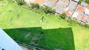 An aerial view of a green park area adjacent to a modern building with a flat roof and a paved walkway. - Modern Look And Comfy Studio Patraland Urbano Apartment (Bekasi)