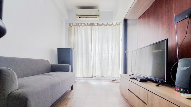 Una sala de estar moderna con un sofá gris, un televisor de pantalla plana y un mueble de madera.