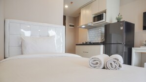 Ein Hotelzimmer mit einem Bett, einer Küchenzeile und einem Kühlschrank.