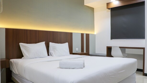 Una habitación de hotel moderna con una cama grande, un escritorio y una silla.