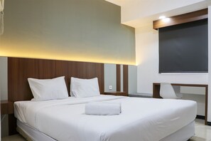 A modern hotel room with a large bed, a desk, and a chair. - Homey And Comfort Stay Studio Room Maple Park Sunter Apartment (Jakarta)
