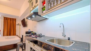 A compact hotel room with a kitchenette, a bed, and a bathroom. - Compact And Nice Studio Tokyo Riverside Pik 2 Apartment (Teluknaga)