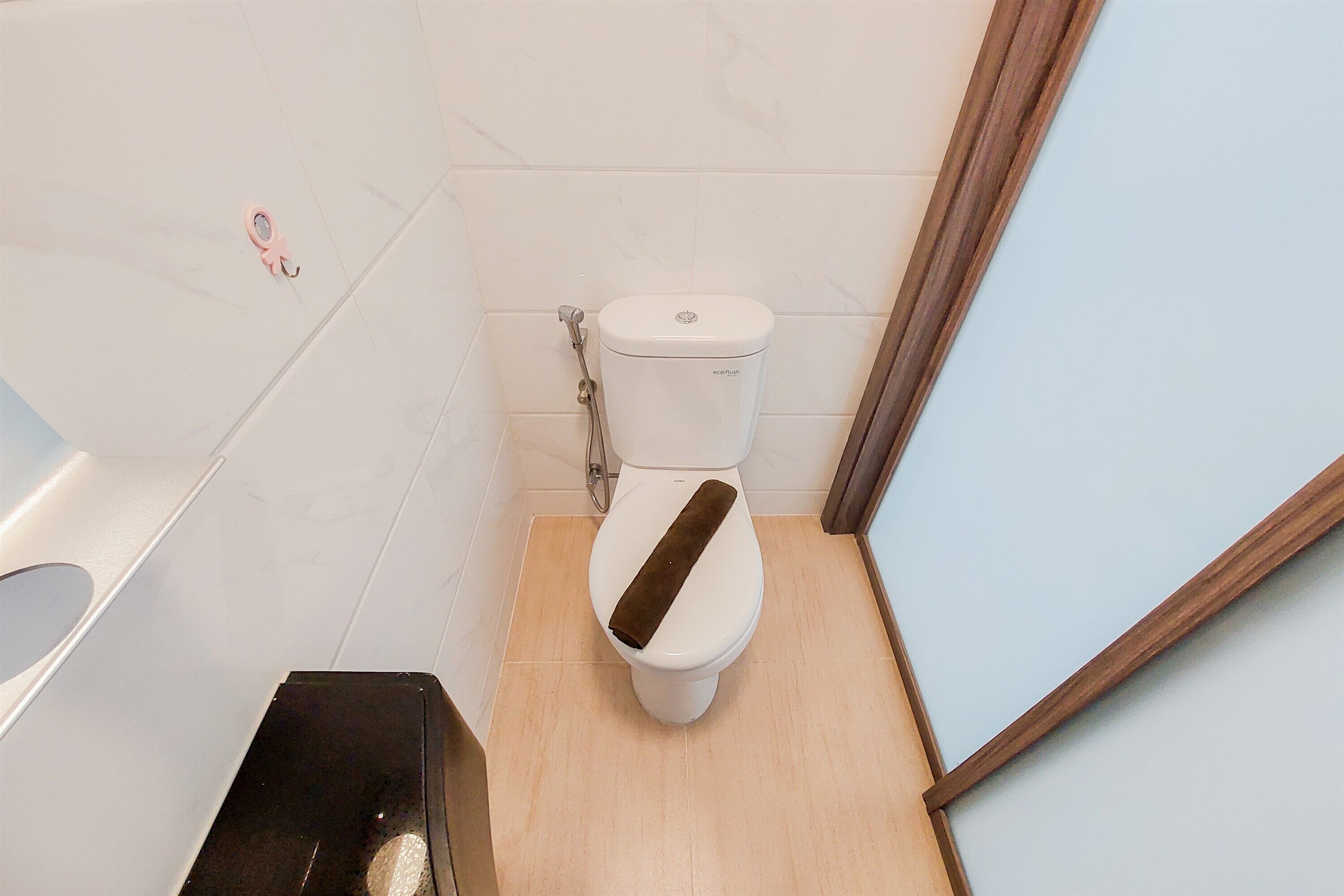A small bathroom with a toilet, a shower, and a sink.