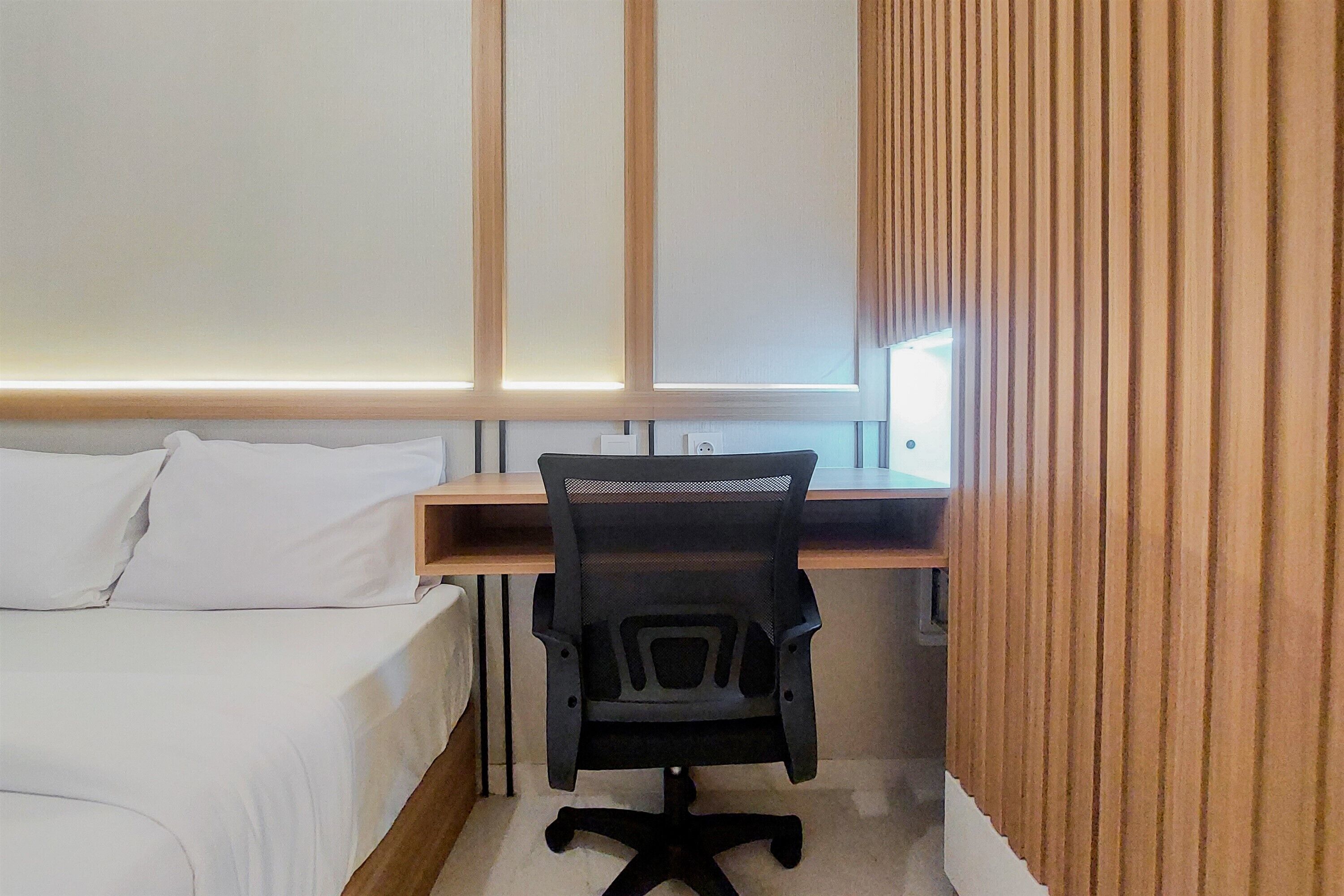 Ein Schlafzimmer mit einem Bett, einem Schreibtisch und einem Stuhl.