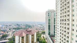 Ein Hochhaus mit mehreren Balkonen und einem Tennisplatz im Erdgeschoss.