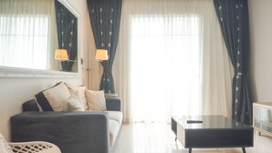 Ein modernes Wohnzimmer mit einer Couch, einem Glastisch und einem Fernseher.