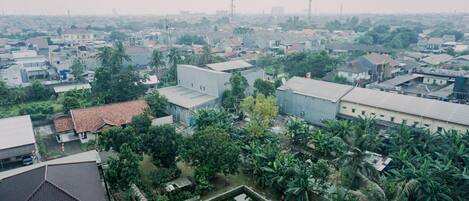 An aerial view of a residential area with houses, a small pond, and surrounding greenery.