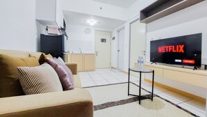 Una sala de estar con un sofá, una mesa de centro y un televisor mostrando el logotipo de Netflix.