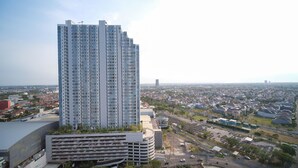Un immeuble de grande hauteur, composé de nombreux étages, entouré d’un quartier résidentiel avec des maisons et des bâtiments plus petits.