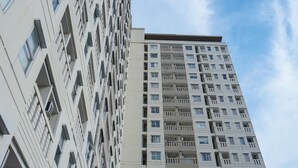 A tall, modern apartment building with multiple balconies and windows. - Homey And Simply Look Studio Belmont Residence Puri Apartment (Jakarta)