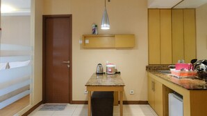 Uma cozinha compacta com uma mesa de madeira, forno embutido e uma pia.