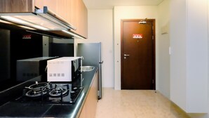 Une cuisine de taille réduite équipée d’une cuisinière, d’un four à micro-ondes et d’un réfrigérateur.