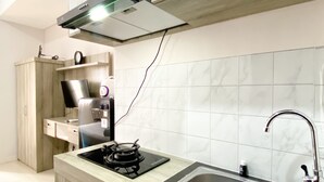 A modern kitchen with a gas stove, stainless steel sink, and a built-in oven. - Best Deal And Cozy Studio At Apartment Transpark Juanda Bekasi Timur (Bekasi)