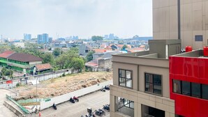 A high-rise building with a parking area in front. - Best Deal And Cozy Studio At Apartment Transpark Juanda Bekasi Timur (Bekasi)