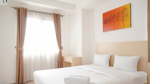 Ein Hotelzimmer mit Bett, Nachttisch, einem Gemälde und einem Fenster mit Vorhängen.