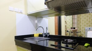Une cuisine moderne dotée d’un plan de travail noir, d’un évier en acier inoxydable et d’une hotte intégrée.