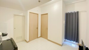 A room with two wooden doors, a dark curtain, and a tiled floor. - Homey And Comfortable 2Br At Tokyo Riverside Pik 2 Apartment (Jakarta)