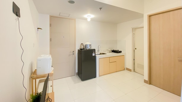 A compact kitchen with a refrigerator, sink, and a small countertop. - Homey And Comfortable 2Br At Tokyo Riverside Pik 2 Apartment (Jakarta)