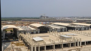 A large industrial building with multiple sections, including a covered parking area and a construction site in the background. - Homey And Comfortable 2Br At Tokyo Riverside Pik 2 Apartment (Jakarta)