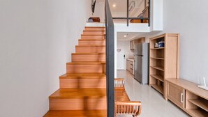 A modern kitchen with wooden cabinets and a built-in oven. - Cozy Stay And Comfy Studio Loft Kingland Avenue Apartment (South Tangerang)