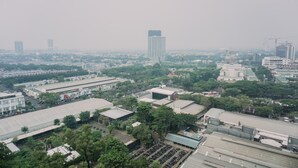 An aerial view of a cityscape with various buildings, including a prominent high-rise in the center. - Cozy Stay And Comfy Studio Loft Kingland Avenue Apartment (South Tangerang)