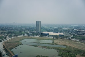 A high-rise building with a flat roof, surrounded by a large body of water and greenery.