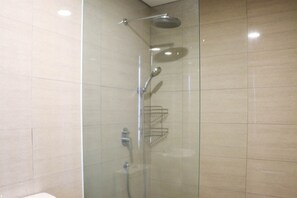 Ducha envuelta en vidrio con cabezal de ducha de mano y cabezal de ducha fijo.