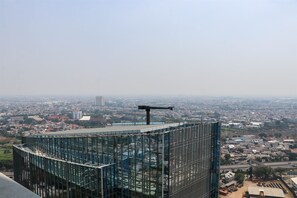 Un edificio moderno de cristal con fachada curva que domina un paisaje urbano.
